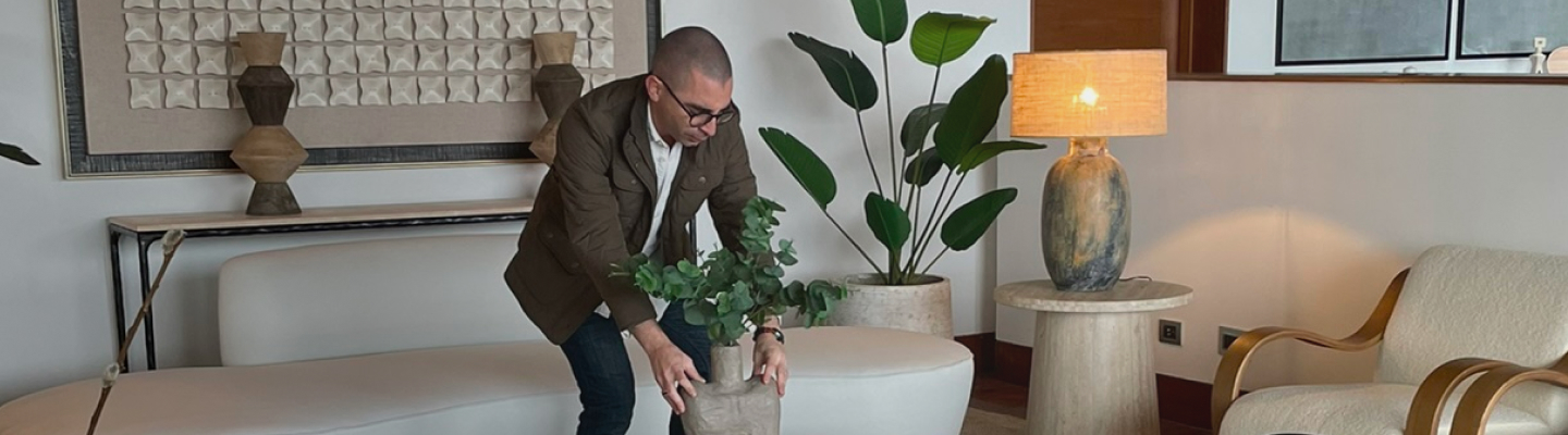 Jose Vivanco acomodando una maceta en una mesa